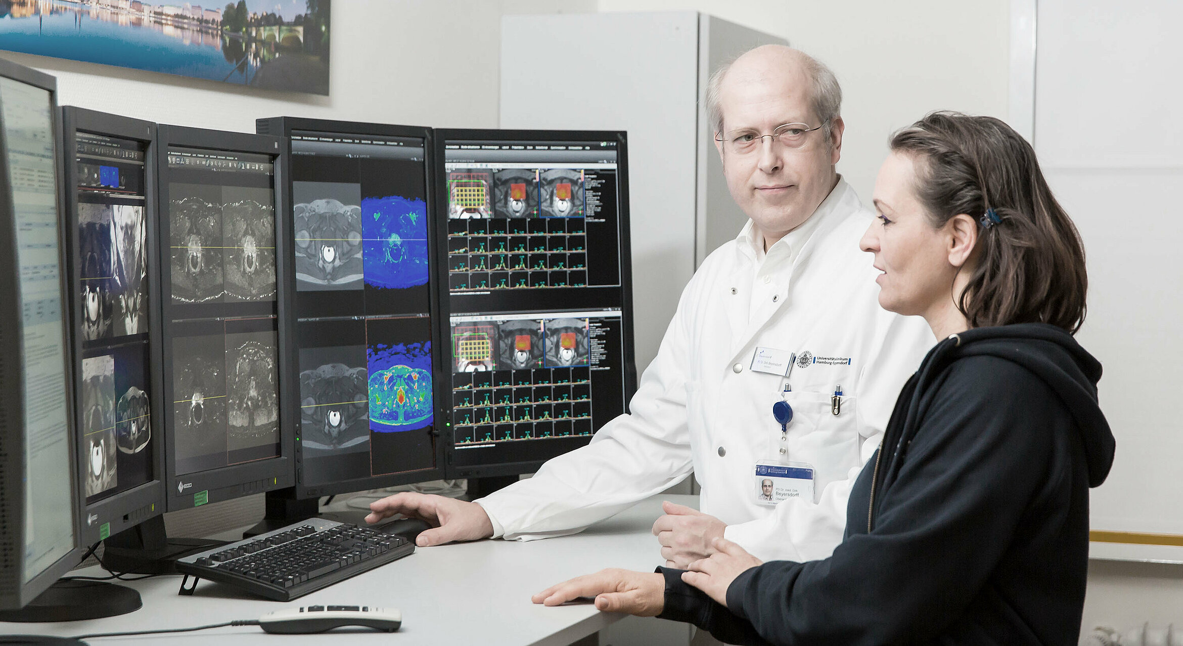 Ein Arzt und eine Schwester der Martini Klinik schauen auf Bildschirme während ein MRT gemacht wird